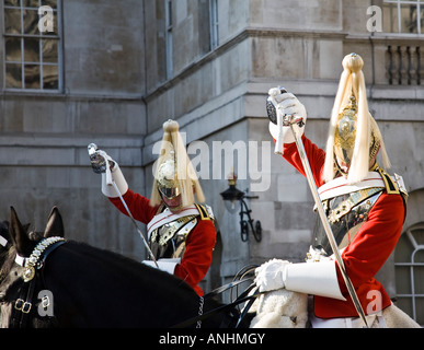 La vie de deux soldats de la garde de la Household Cavalry Regiment placer leurs épées dans leurs fourreaux à l'unisson avant de descendre. Banque D'Images