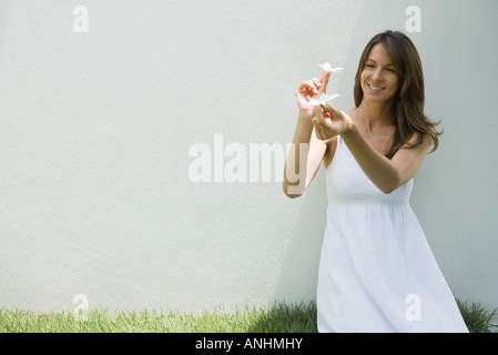 Femme en robe d'holding fake papillons, smiling Banque D'Images