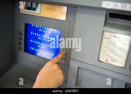 Personne à l'aide d'un distributeur automatique en Chine, cropped view Banque D'Images