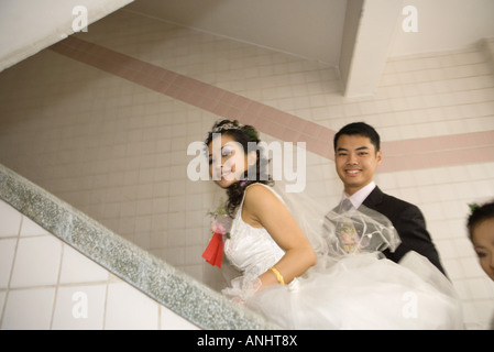 Mariée et le marié en montant un escalier Banque D'Images