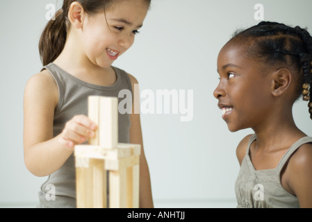 Deux jeunes filles jouant avec des blocs, smiling at each other Banque D'Images