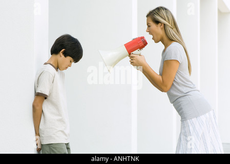 Femme criant à boy par mégaphone Banque D'Images