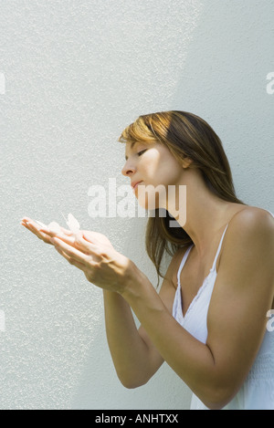 Woman holding fake papillons en main Banque D'Images