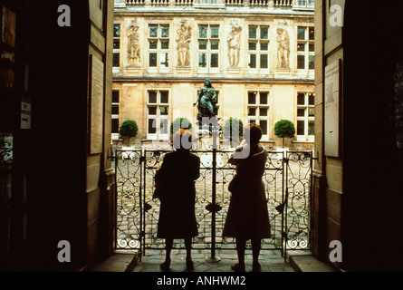 Europe France Paris le quartier du Marais deux femmes regardant la cour du Musée Carnavalet. Musée dédié à l'histoire de Paris. Banque D'Images