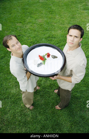 Deux hommes tenant jusqu'rock garden, l'un souriant, l'autre froncer, high angle view Banque D'Images