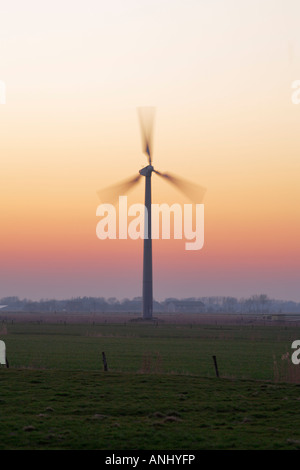 Wind turbine in motion au coucher du soleil, Frise du Nord Allemagne ---- moulin à vent / à farine alternative energy power generation Banque D'Images