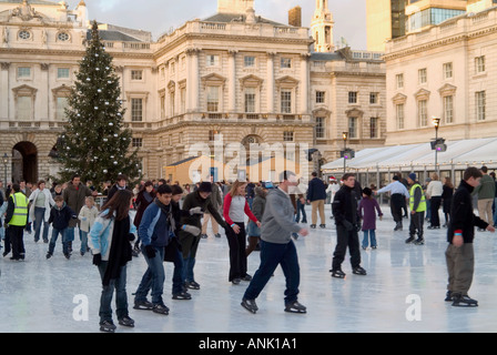 Cour historique de Somerset House avec décorations d'arbres de Noël et personnes appréciant l'arène de patinage sur glace extérieure au Strand London Angleterre Banque D'Images