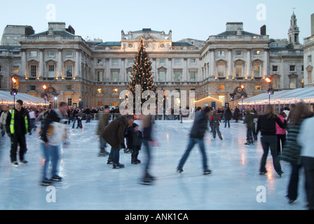 Cour historique de Somerset House avec décorations d'arbres de Noël et personnes appréciant l'arène de patinage sur glace extérieure au Strand London Angleterre Banque D'Images