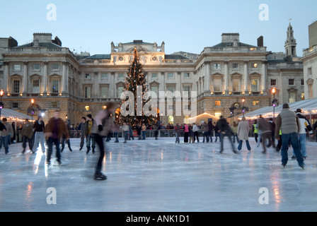 Cour historique de Somerset House avec décorations d'arbres de Noël et personnes appréciant l'arène de patinage sur glace extérieure au Strand London Angleterre Banque D'Images