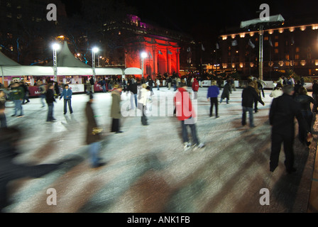 Motion Blur skateurs les gens sur la patinoire à Noël illuminé En hiver, patinoire West End Marble Arch allumée en rouge Projecteurs Londres Angleterre Royaume-Uni Banque D'Images