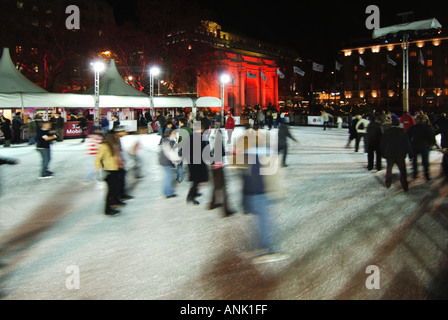 Motion Blur skateurs les gens sur la patinoire à Noël illuminé En hiver, patinoire West End Marble Arch allumée en rouge Projecteurs Londres Angleterre Royaume-Uni Banque D'Images