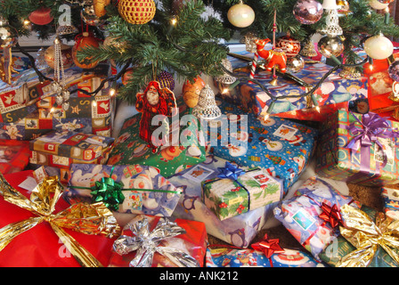 Des cadeaux de Noël éparpillés autour de la base d'un arbre de Noël dans le salon intérieur Banque D'Images