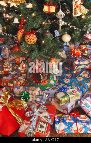 Des cadeaux de Noël éparpillés autour de la base d'un arbre de Noël dans le salon intérieur Banque D'Images