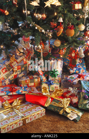 Des cadeaux de Noël éparpillés autour de la base d'un arbre de Noël dans le salon intérieur Banque D'Images