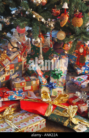 Des cadeaux de Noël éparpillés autour de la base d'un arbre de Noël dans le salon intérieur Banque D'Images
