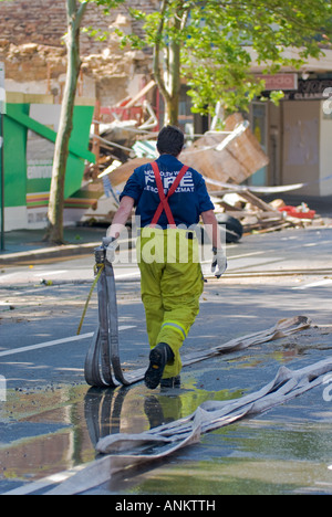 Fire fighter au travail le nettoyage après la démolition d'un immeuble Banque D'Images