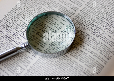 Une loupe est situé sur une page ouverte d'un ancien dictionary Banque D'Images