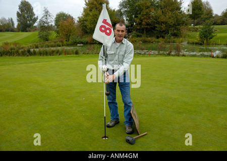 Green-keeper changer la tête d'un trou sur le parcours de golf. Banque D'Images