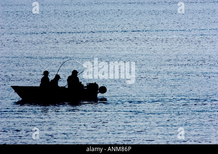 La silhouette du pêcheur La pêche tôt le matin en petit bateau Banque D'Images