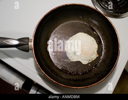 Overeasy oeuf dans une poêle sur une cuisinière blanc Banque D'Images