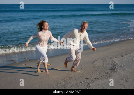 Couple running on beach Banque D'Images