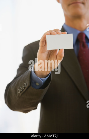 Businessman holding up business card Banque D'Images