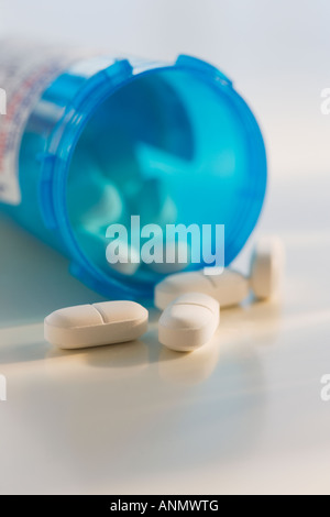 Close up of pills spilling out of bottle Banque D'Images