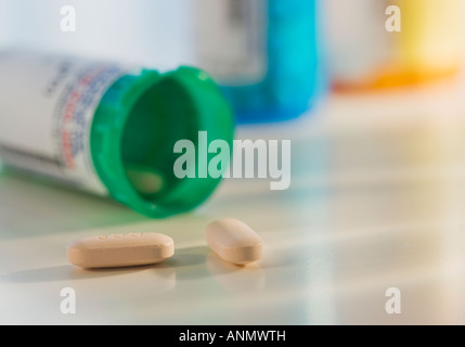 Close up of pills spilling out of bottle Banque D'Images