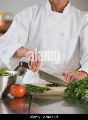 Femme chef chopping vegetables Banque D'Images