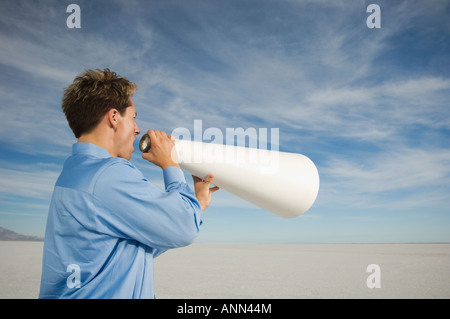 Businessman yelling into megaphone, Salt Flats, Utah, United States Banque D'Images