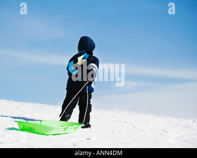 Tirant de l'enfant dans la neige Traîneau Banque D'Images