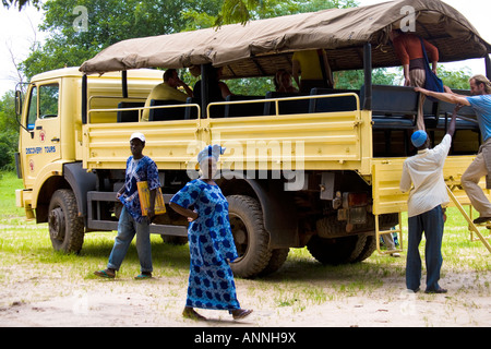 Les touristes de remonter à bord d'un camion de découverte au cours d'une excursion en Gambie, Afrique de l'ouest Banque D'Images