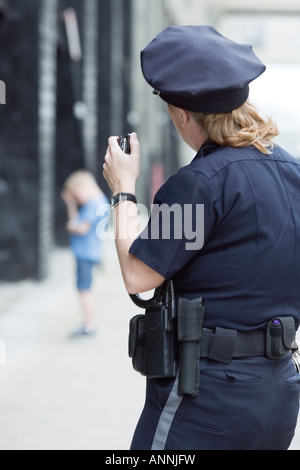 Femme agent de police à parler sur un micro main. Banque D'Images