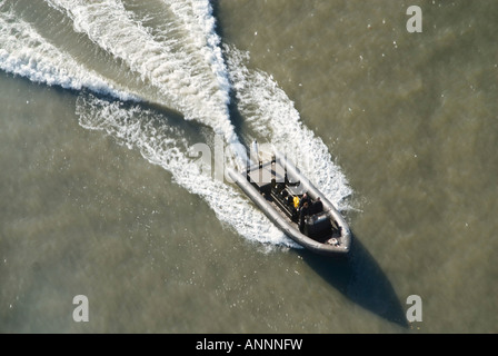 L'horizontale Vue aérienne d'un bateau gonflable rigide [R.I.B.] ou roulant à vitesse le long d'une rivière sur une journée ensoleillée Banque D'Images