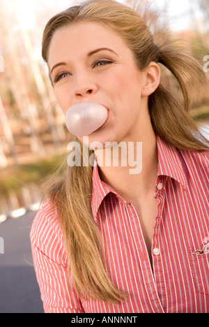 Stock photo montrant gros plan du caucasian girl de 15 à 17 ans de sourire et souffler avec de la gomme à bulles USA Banque D'Images