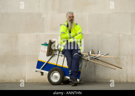 Close up portrait of horizontal d'un conseil street cleaner assis sur son panier d'avoir une pause. Banque D'Images