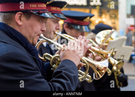 Close up horizontale de trompettistes dans un brass band de l'Armée du Salut jouant des chants de Noël pour recueillir des fonds pour la charité. Banque D'Images