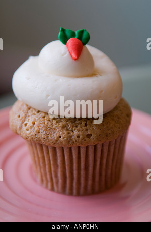 Cupcake carotte avec de fromage fondu sur une plaque rose sur une table. Banque D'Images