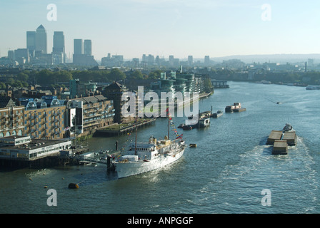 Vue aérienne sur la Tamise King of Norway Royal Yacht amarré À HMS Président en paysage urbain avec Canary Wharf à Londres Docklands au-delà de l'Angleterre Royaume-Uni Banque D'Images