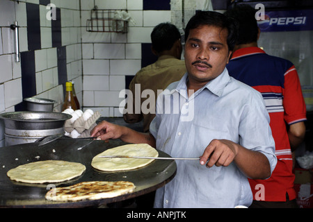 Un cuisinier prépare un plat favori Bengali, Kathi rouleaux, sur un parc en tawa Street, Kolkata, Inde. Banque D'Images