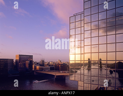 L'aube sur le pont de Londres et la Tamise avec le Tower Bridge en compte dans la fenêtre en verre moderne bureau de la banque mondiale d'un block London UK Banque D'Images