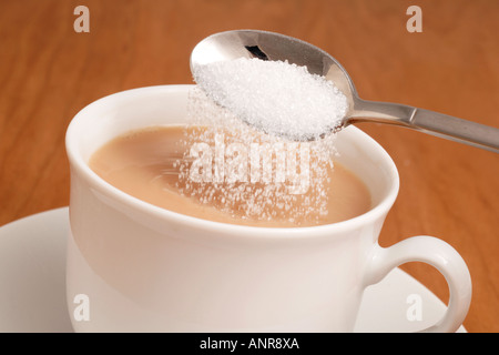 L'ajout de sucre blanc granulé de tasse de thé Banque D'Images