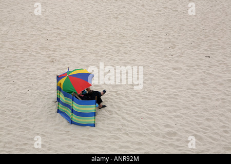 Abritant un couple sur la plage de Porthmeor St Ives Cornwall England Banque D'Images