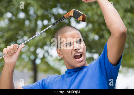 Close-up of a Teenage boy holding a golf club et crier Banque D'Images