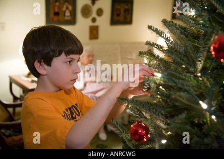 L'arbre de Noël décore garçon comme grand-mère de 100 ans se trouve à proximité Banque D'Images