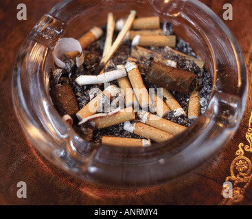 [^^cendrier en verre] plein de cigarettes et mégots de cigare Banque D'Images