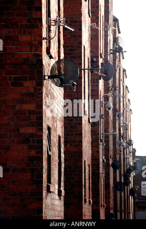 Myriade d'antennes satellites et de caméras de surveillance fixé à côté de tenement block à Barrow-in-Furness, Cumbria, Angleterre Banque D'Images