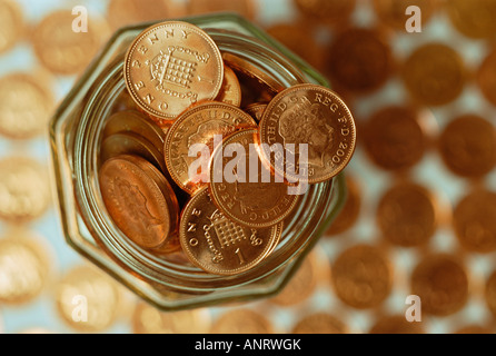 Un cent pièces de monnaie dans un bocal en verre sur fond de penny de monnaie, close-up Banque D'Images