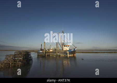 Bateau de pêche à marée haute au homard et des casiers à crabe Brancaster staithe Angleterre Norfolk Janvier Banque D'Images