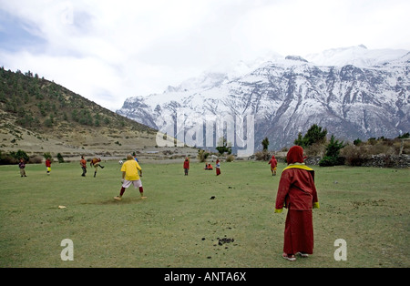 Les moines étudiants jouant au football. Près de Ngawal village. Circuit de l'Annapurna trek. Le Népal Banque D'Images